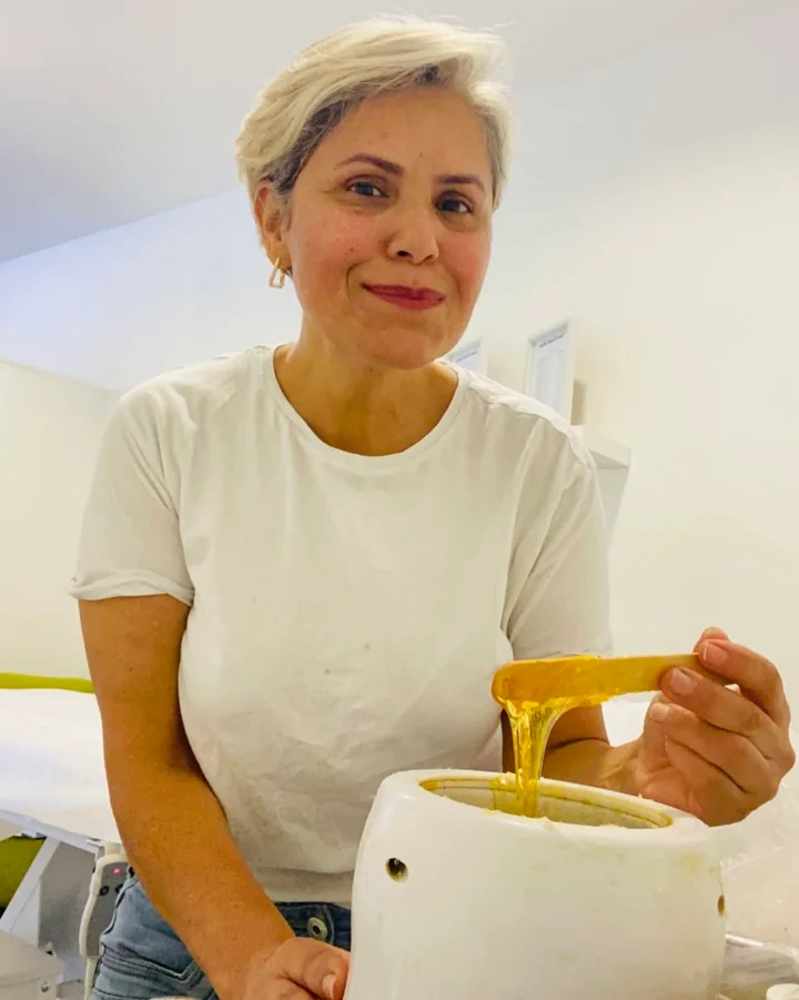 Janete, Inhaberin und ausgebildete Depiladora, bei der Arbeit mit warmem Wachs in ihrem Studio in Aschaffenburg
