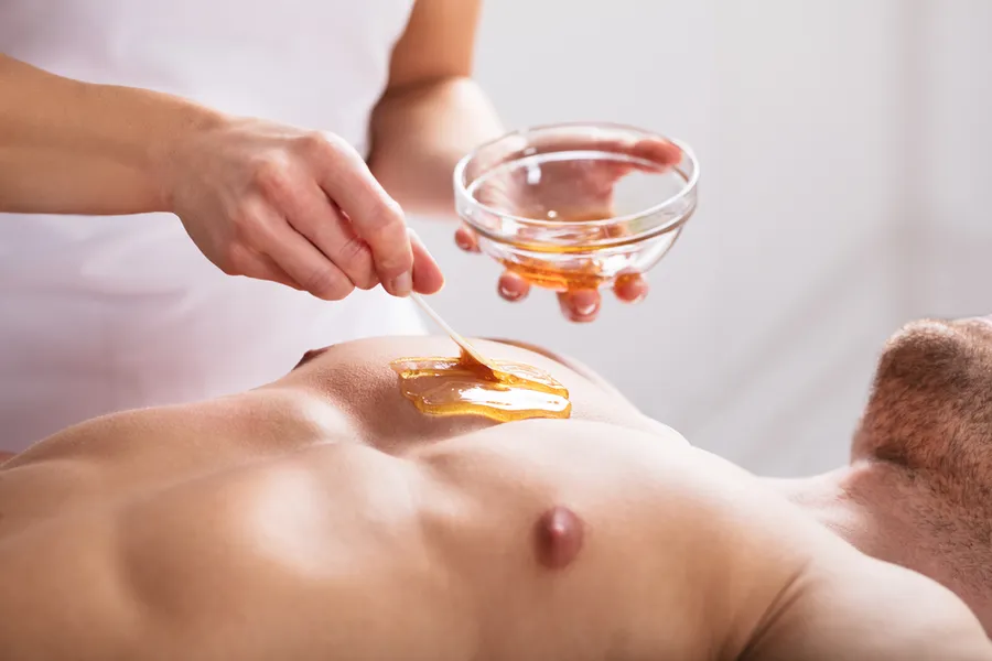 Warmwachs-Behandlung an der Brust eines Mannes im Studio von Janetes Brazilian Waxing